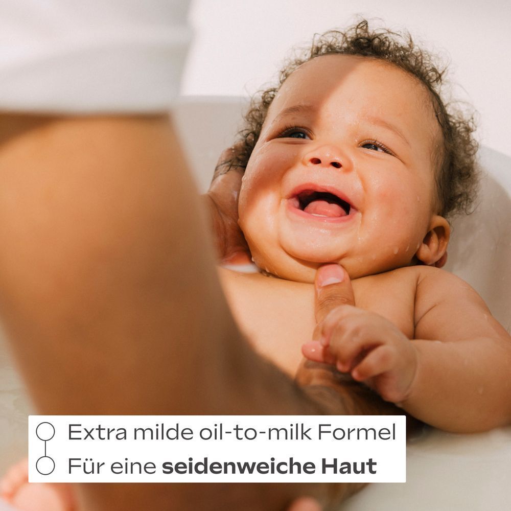 Ein lachendes Baby in der Badewanne. Text: Extra milde Öl-in-Milch-Formel für seidig-zarte Haut.