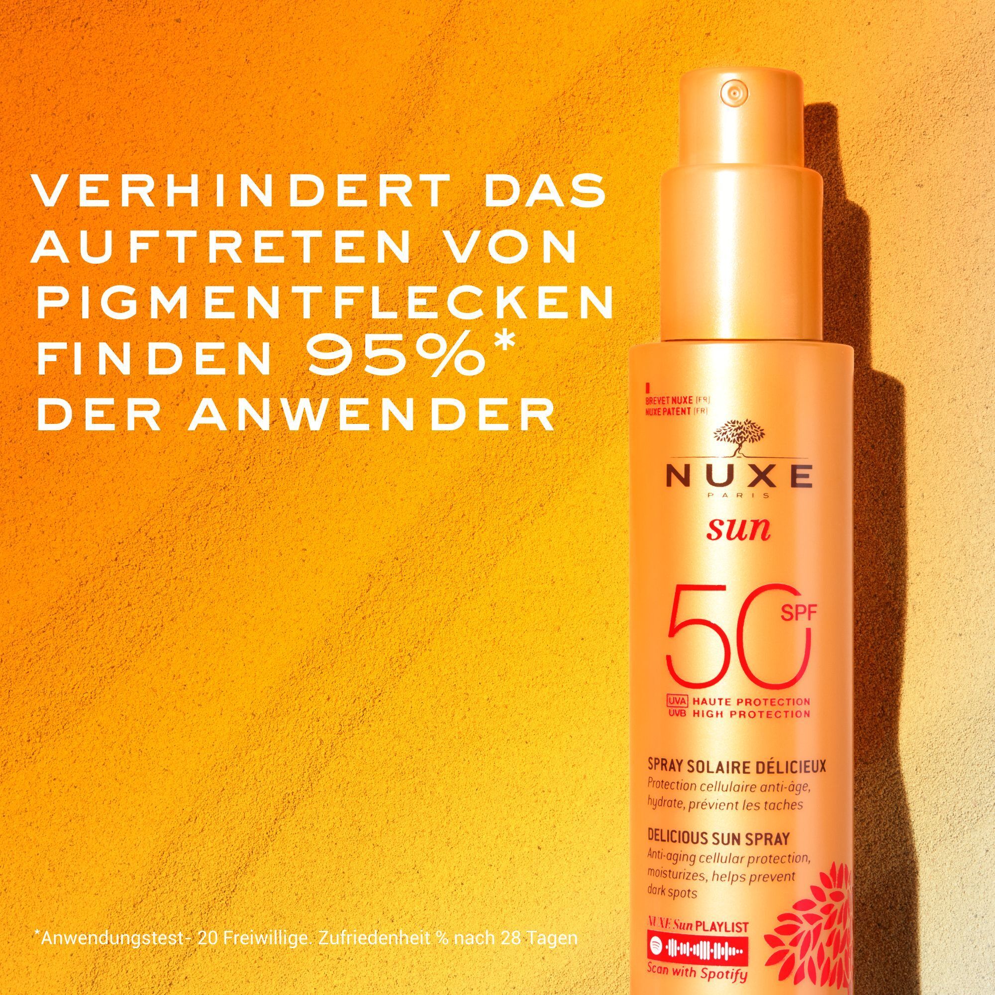 Nuxe Sun Sonnenspray LSF 50 vor sandigem Hintergrund. Verhindert Pigmentflecken.
