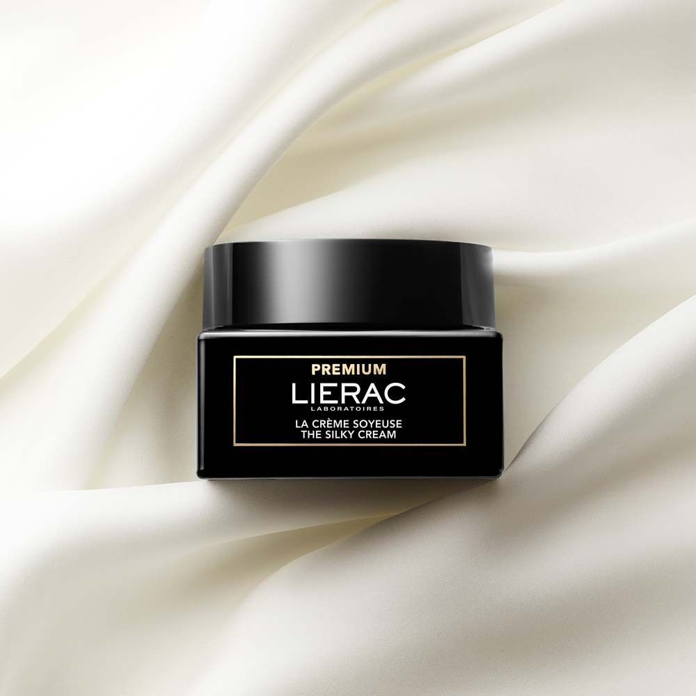 LIERAC Premium Seidige Creme Tiegel auf fließendem weißem Stoff.