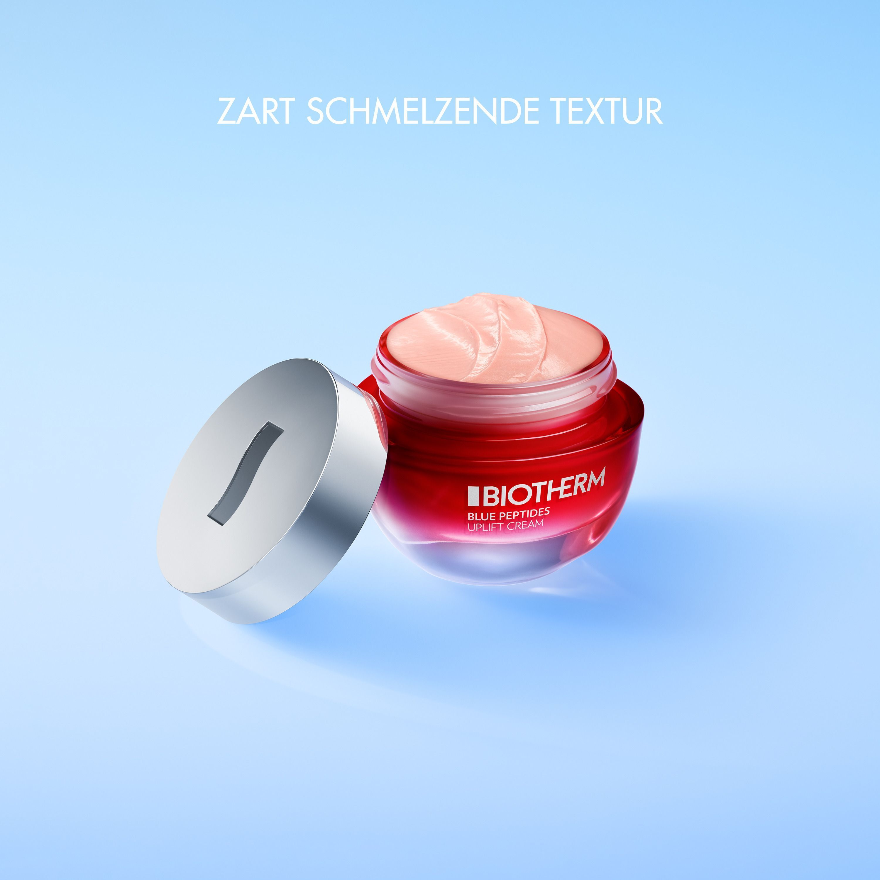 Ein offener roter Tiegel Biotherm Blue Peptides Uplift Cream mit silbernem Deckel daneben.