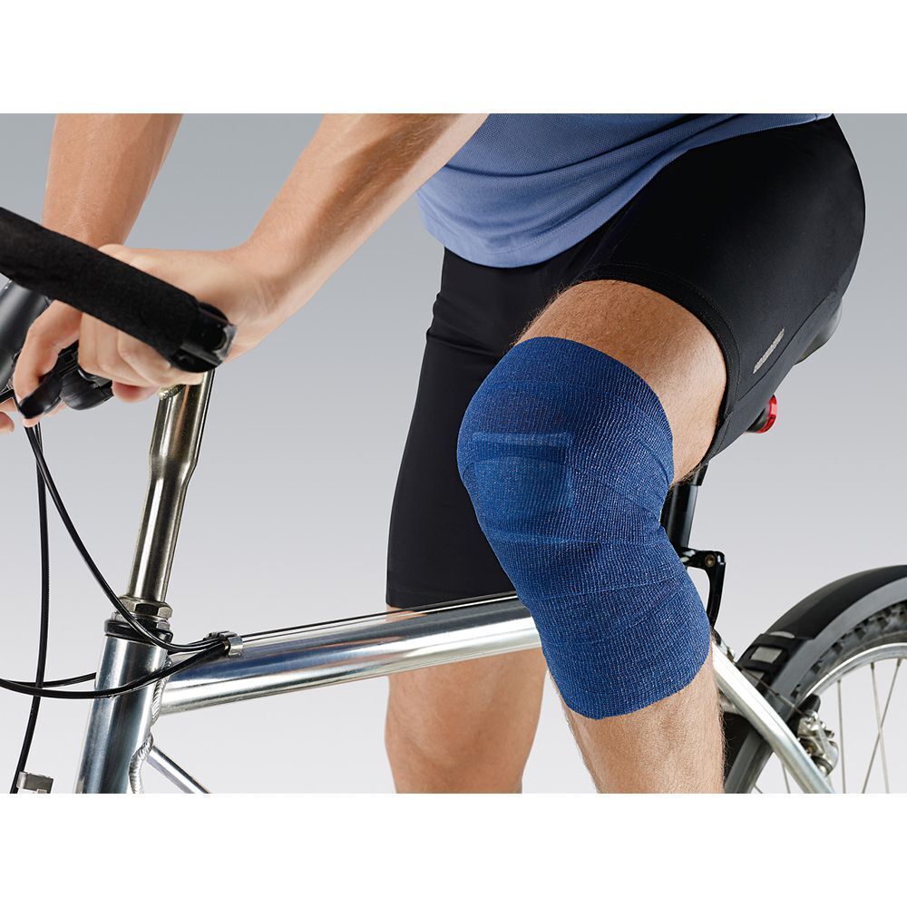 Ein Mann mit einer blauen Peha-haft Color Binde am Knie, der Fahrrad fährt.