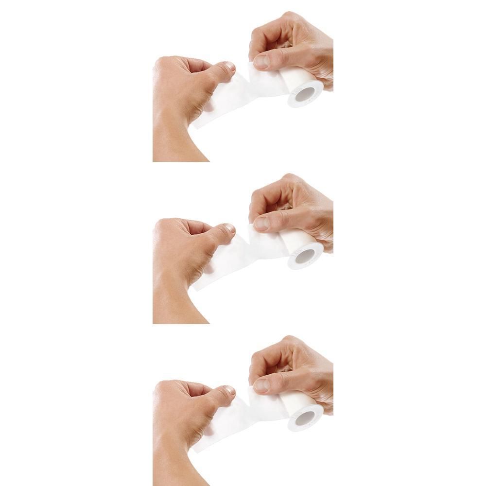 Hände wickeln ein weißes medizinisches Klebeband von einer Rolle ab.