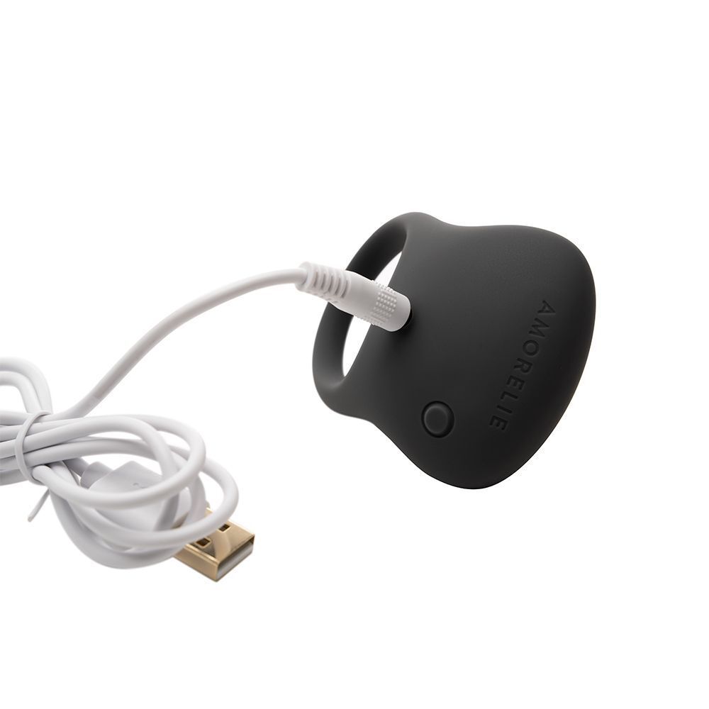 Grauer AMORELIE Penisring Boom Boom wird mit USB-Kabel geladen.