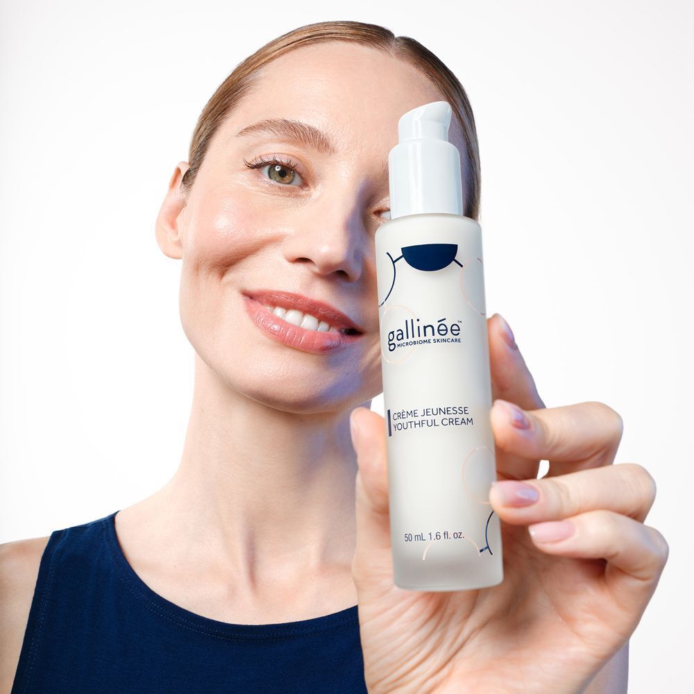 Frau hält eine Flasche Gallinee Youthful Cream.