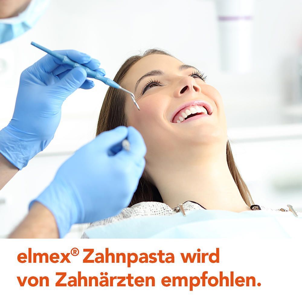 Zahnarzt untersucht die Zähne einer lächelnden Patientin, elmex Zahnpasta wird empfohlen.