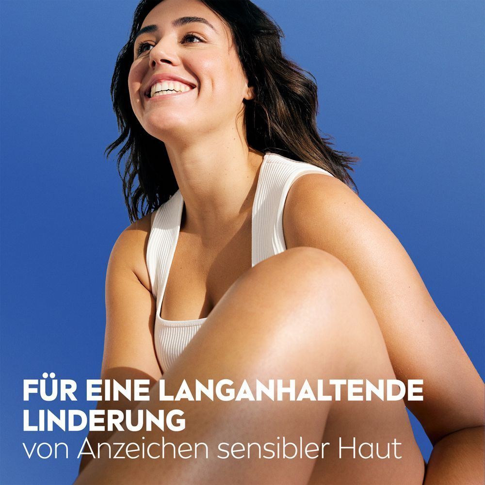 Frau mit strahlendem Lächeln im Freien. Text: Für eine langanhaltende Linderung von Anzeichen sensibler Haut.