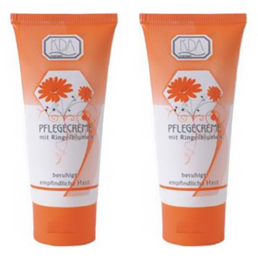 Zwei Tuben KDA Pflegecreme mit Ringelblumen. Orangefarbene Tuben mit weißem und orangefarbenem Etikett, das Blumen zeigt.