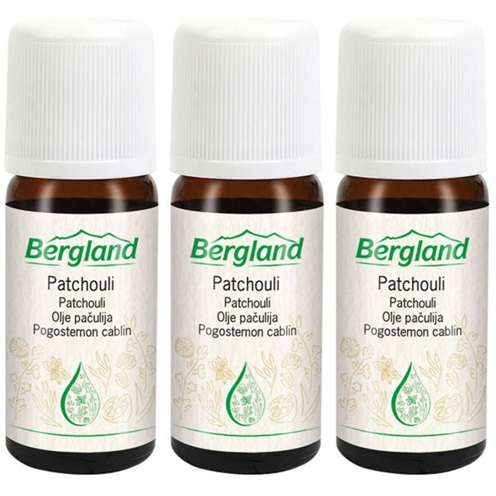Drei Flaschen Bergland Patchouli Öl mit weißen Schraubverschlüssen. Braune Glasflaschen mit Etiketten, die grüne Muster und Text zeigen.