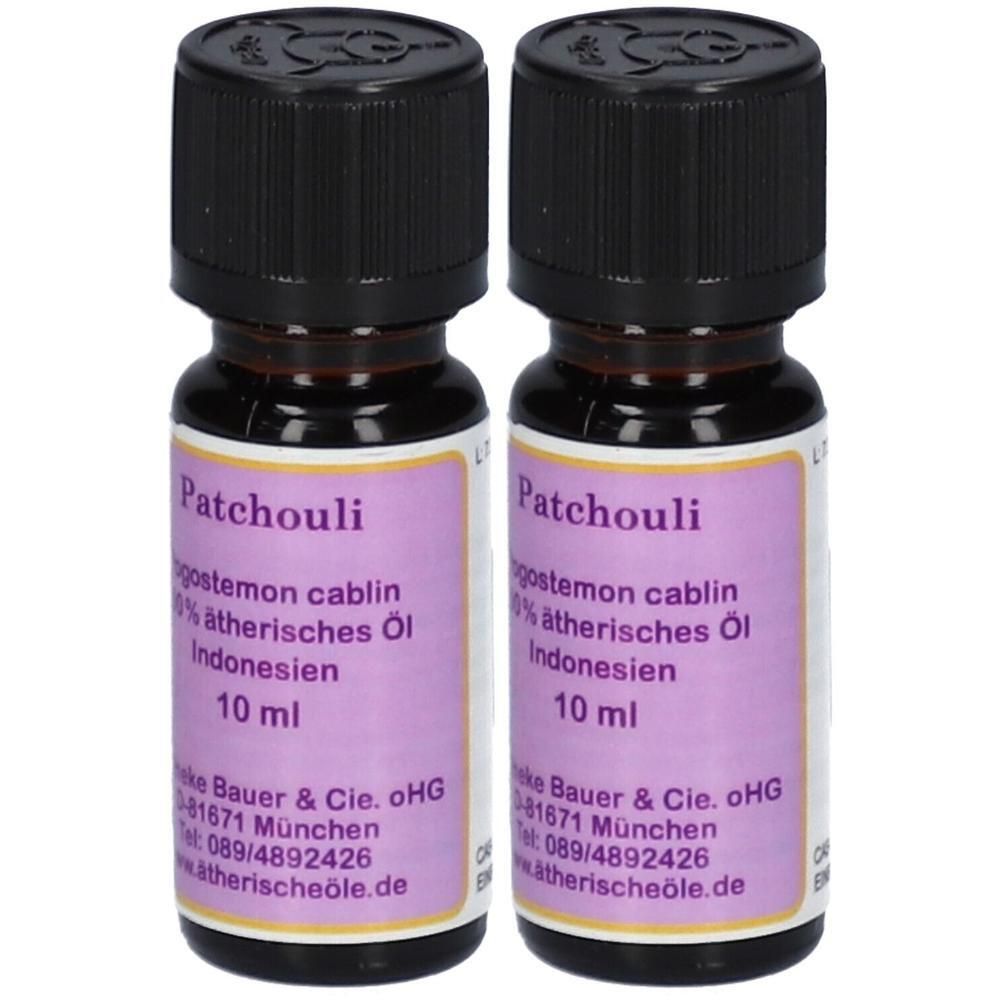 Zwei 10ml Flaschen Patchouli ätherisches Öl mit schwarzen Schraubverschlüssen. Lila Etiketten mit Produktinformationen.