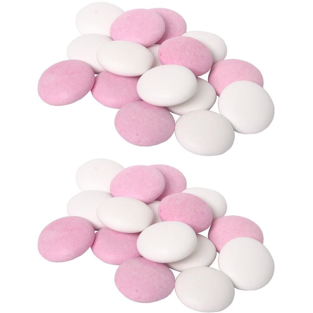 Zwei Haufen von rosa und weißen Schokolinsen.