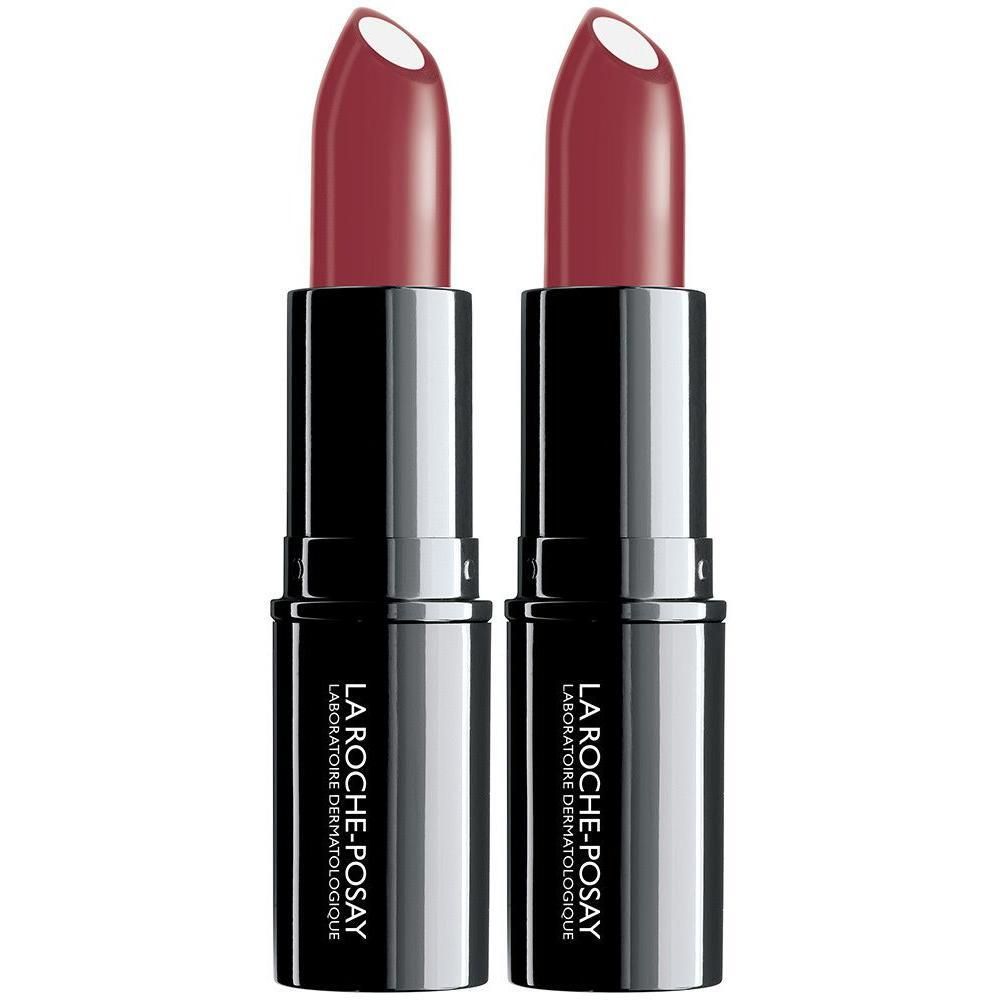 Zwei Lippenstifte von La Roche-Posay in dunkler Verpackung mit silbernen Akzenten. Die Lippenstiftfarbe ist ein tiefes Rot.