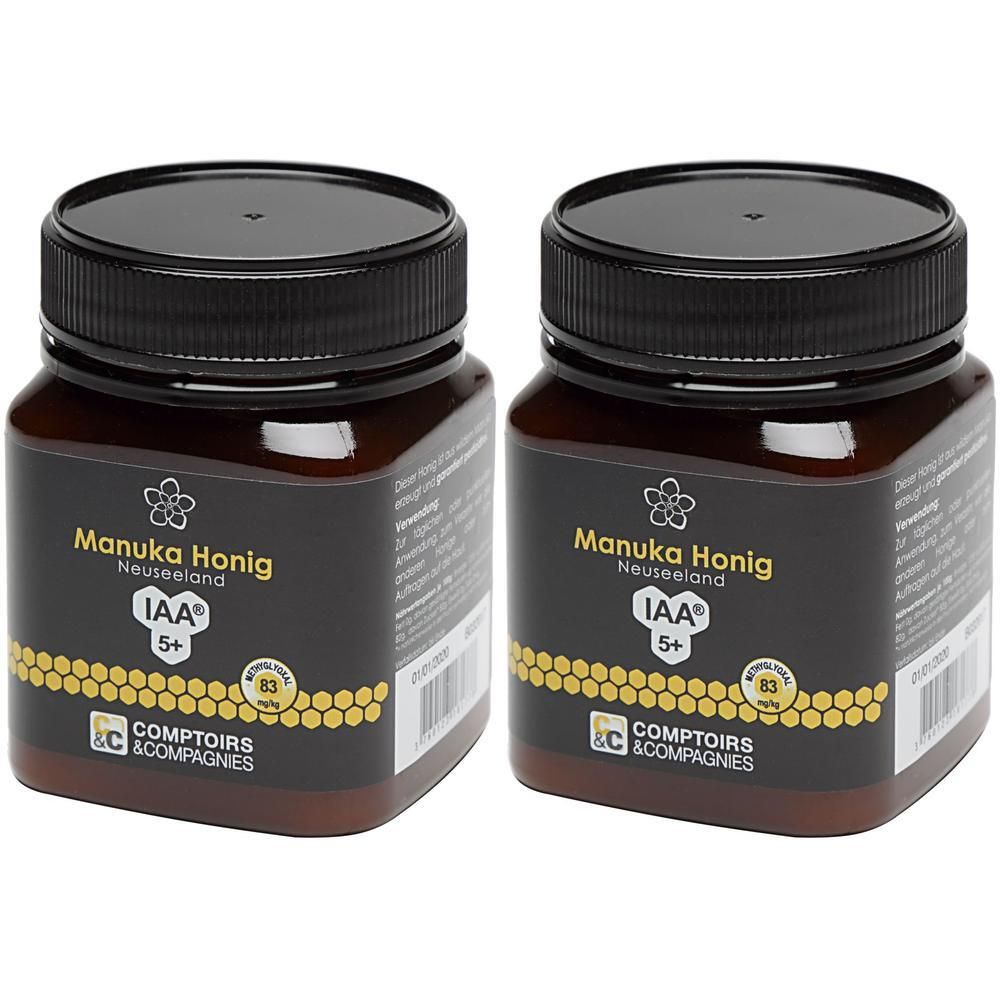 Zwei Gläser Manuka Honig mit schwarzen Deckeln und Etiketten, die 'Manuka Honig Neuseeland IAA 5+' zeigen.