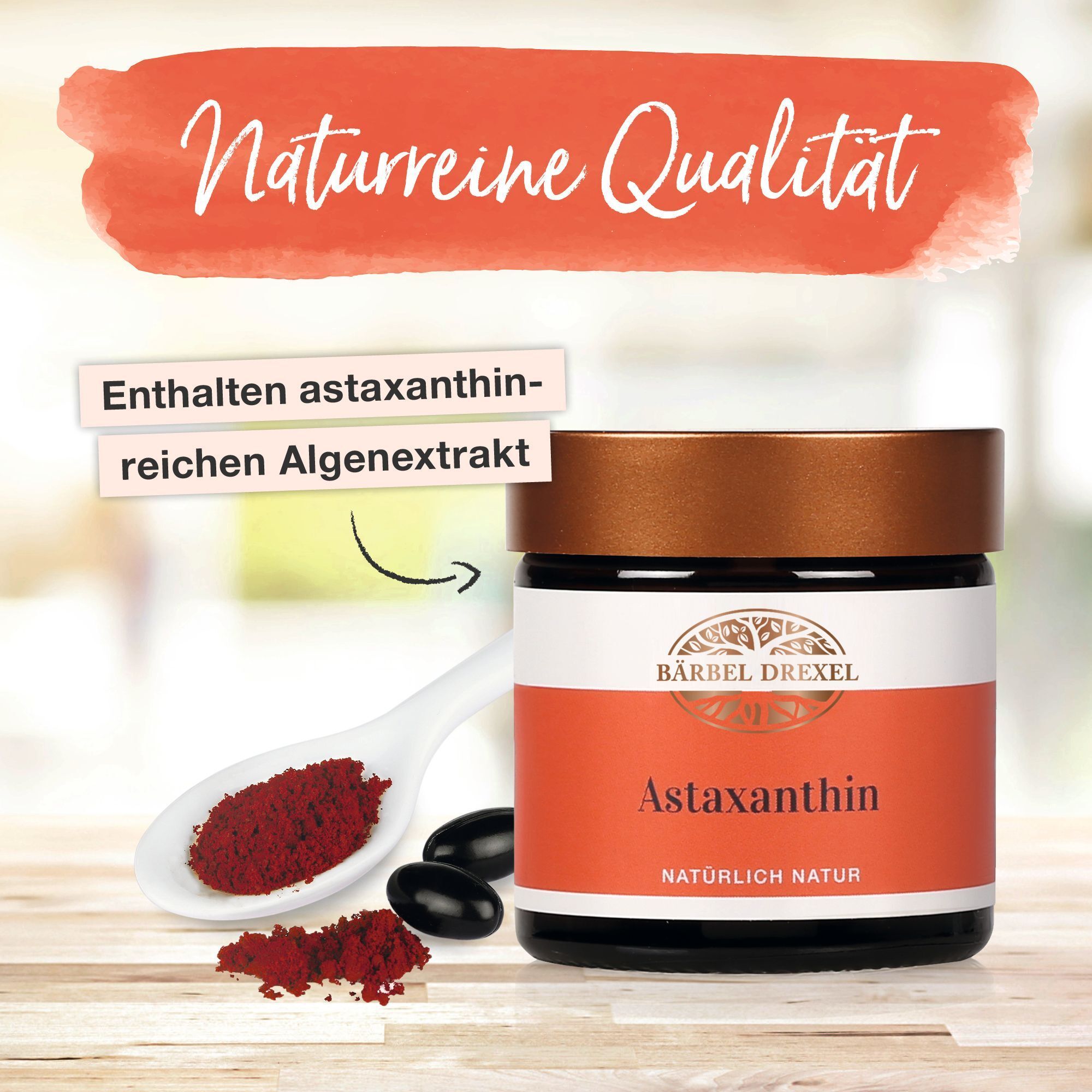 Bärbel Drexel Astaxanthin Kapseln auf einem Löffel und vor einem Glas.