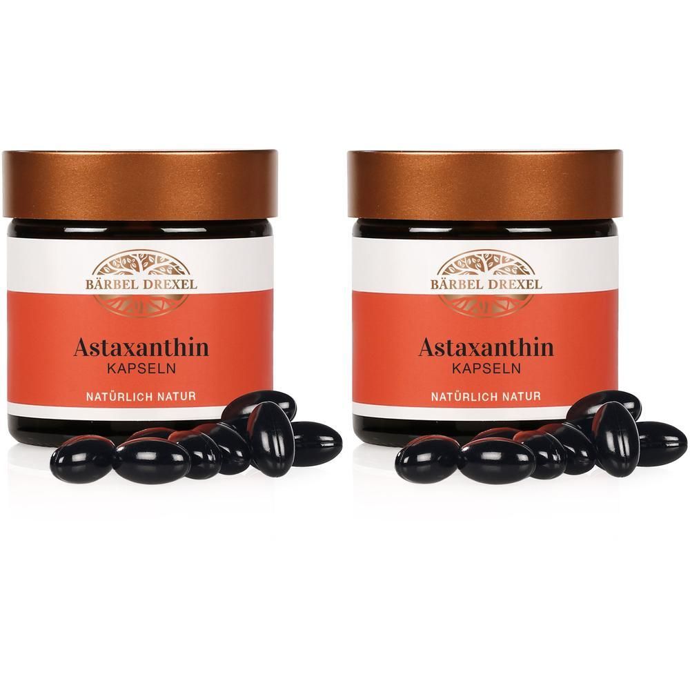 Zwei Gläser Bärbel Drexel Astaxanthin Kapseln mit verstreuten Kapseln.