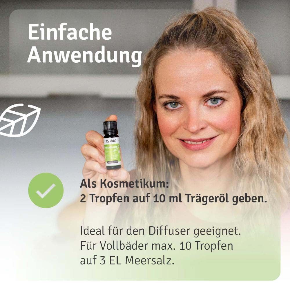 Eine Frau hält eine Flasche Casida Bergamotte Öl, 100% naturrein, mit Etikett und schwarzem Deckel.