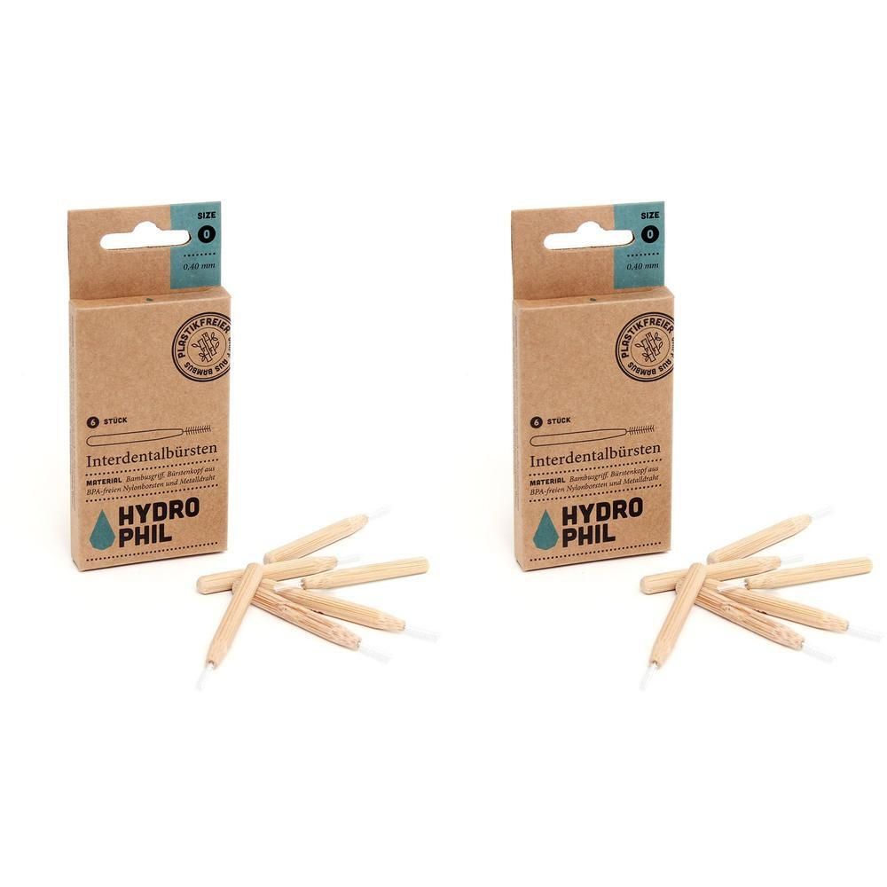 Zwei Packungen HYDROPHIL Interdentalbürsten aus Bambus, daneben liegen mehrere Bürsten.