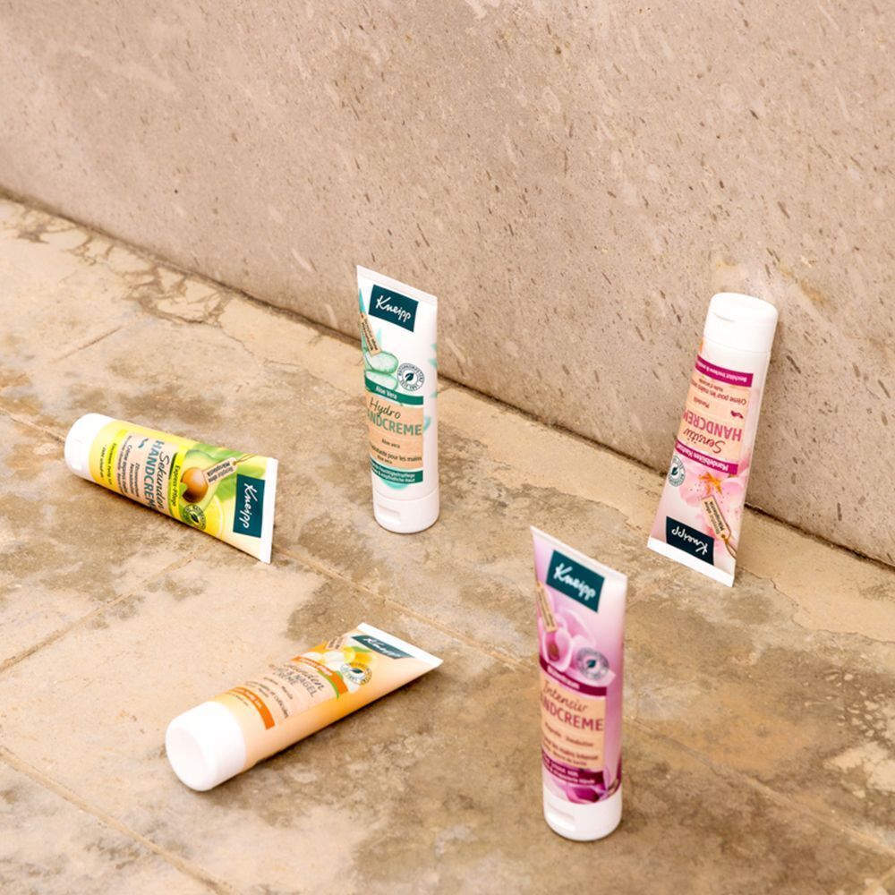 Fünf Tuben Handcreme verschiedener Sorten von Kneipp, auf einem gefliesten Untergrund.