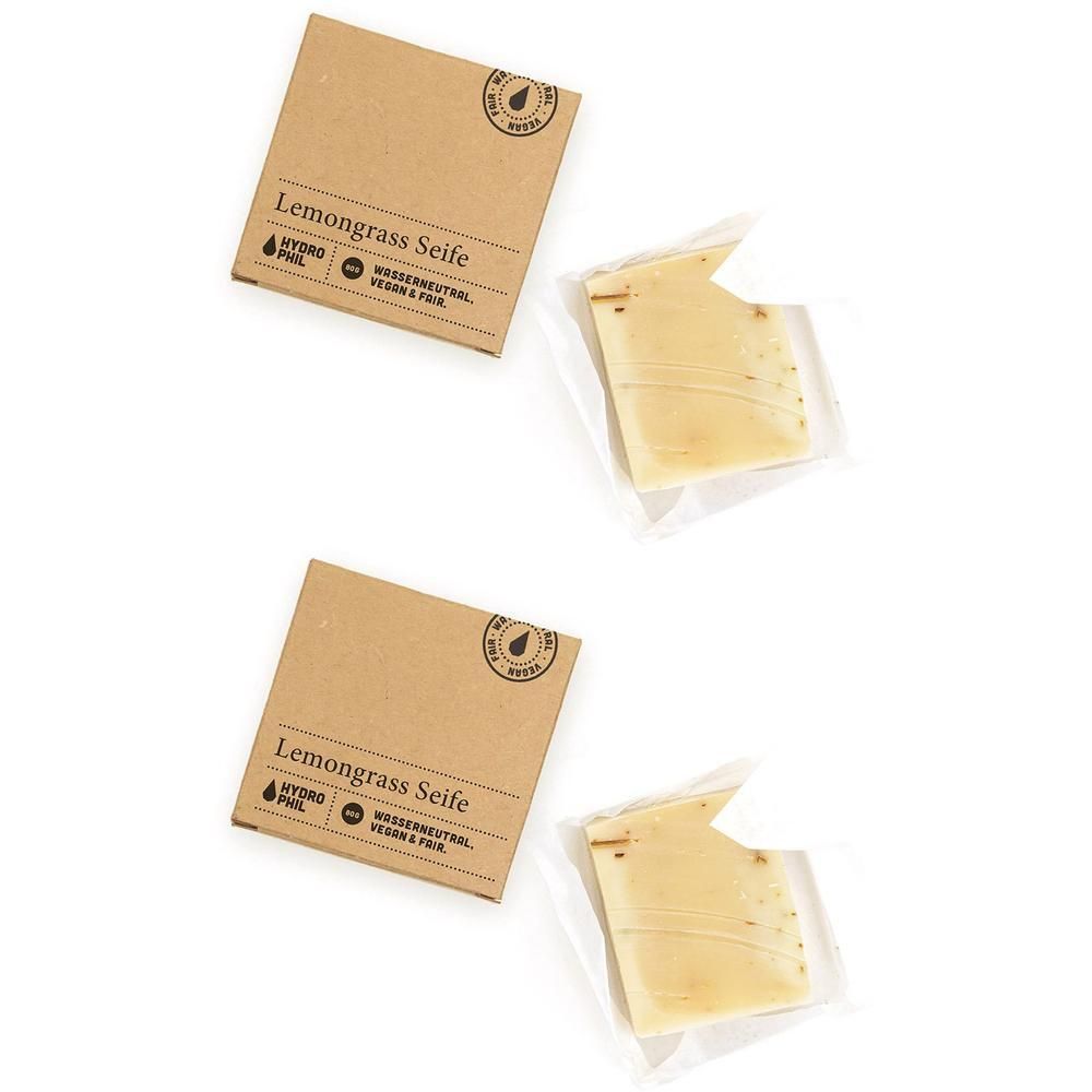 Zwei Packungen Lemongras-Seife, jeweils eine Seife in Folie verpackt. Kartons mit Produktinformationen.