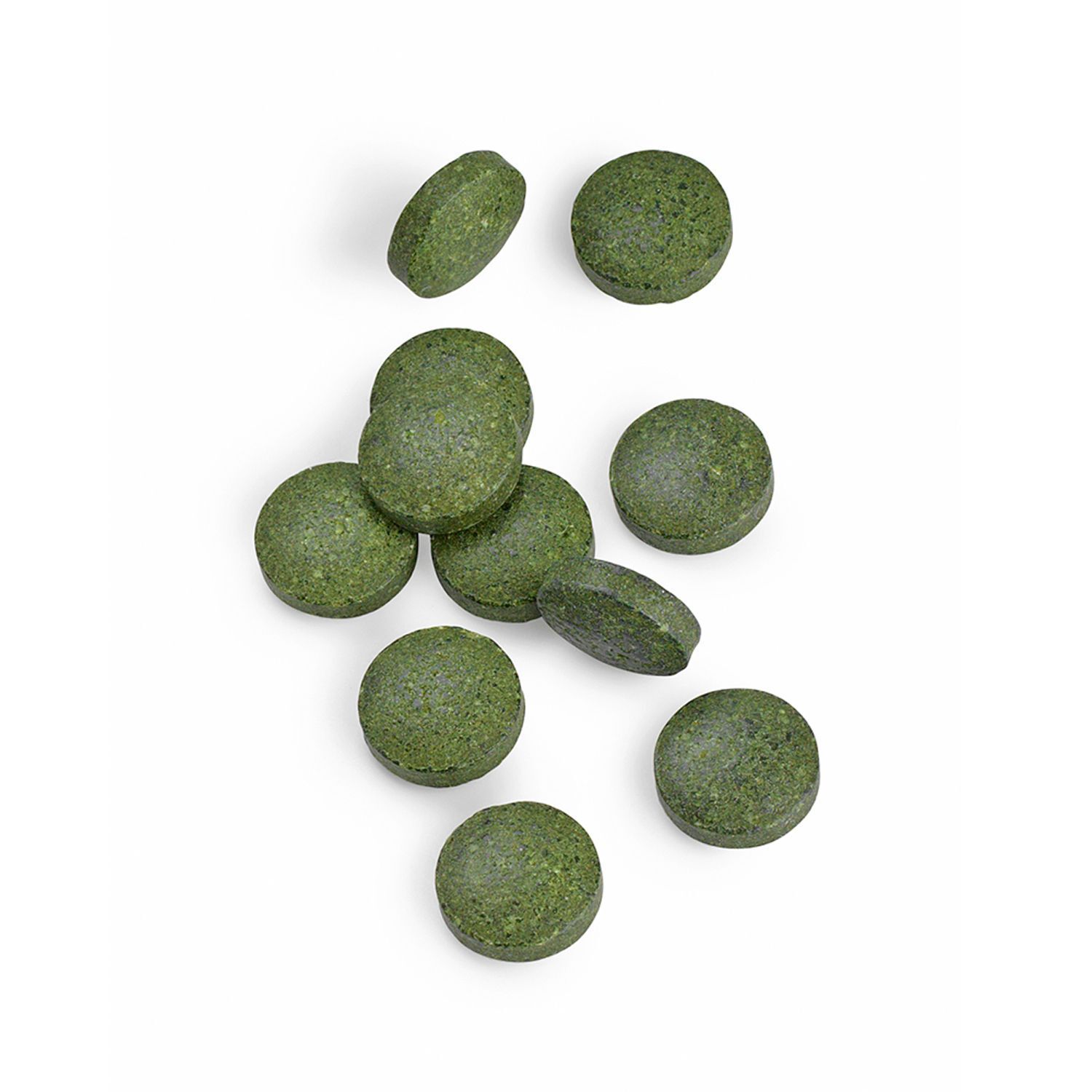 Mehrere grüne Tabletten, einige liegen flach, andere stehen aufrecht.