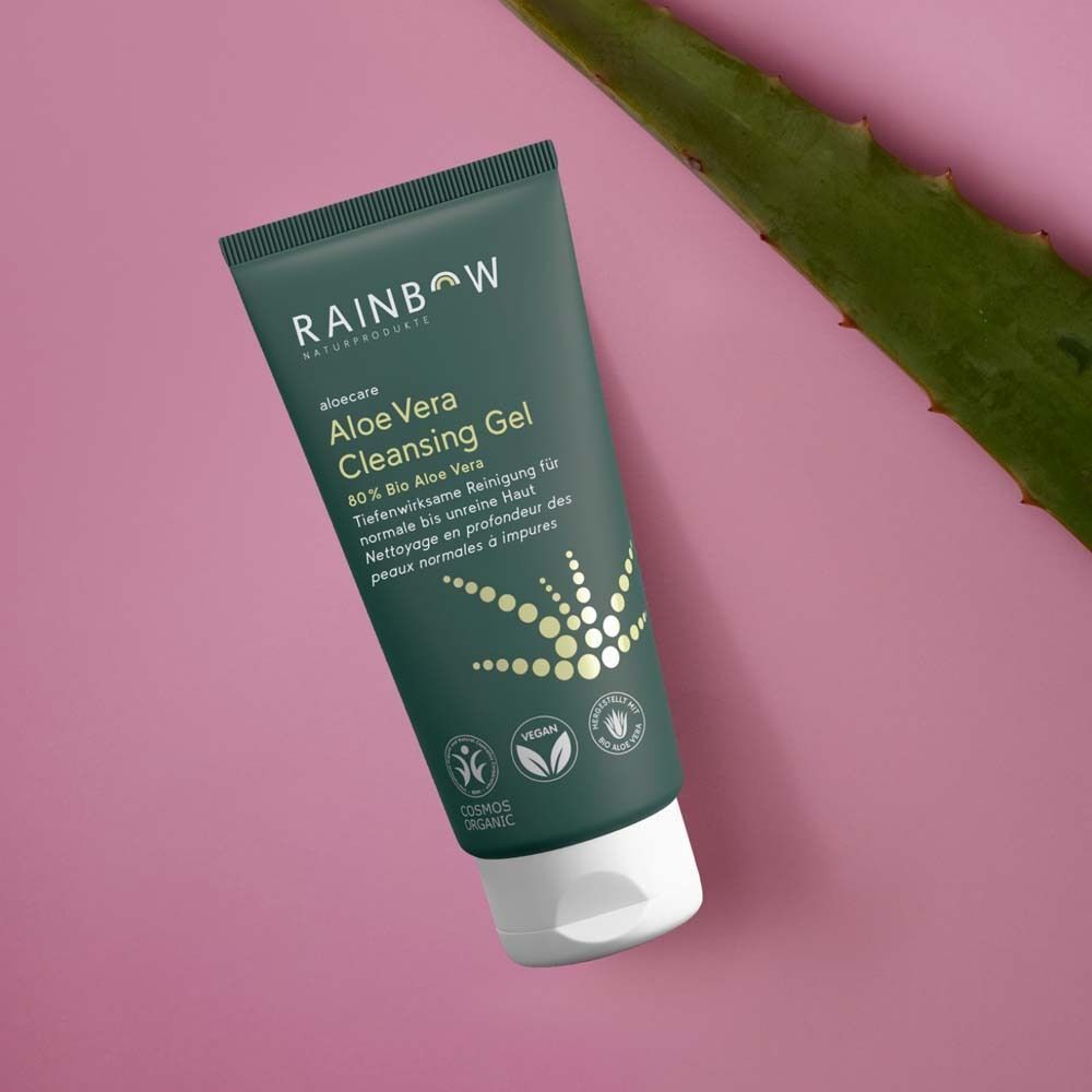 Eine Tube Rainbow aloecare Aloe Vera Cleansing Gel neben einem Aloe-Vera-Blatt.