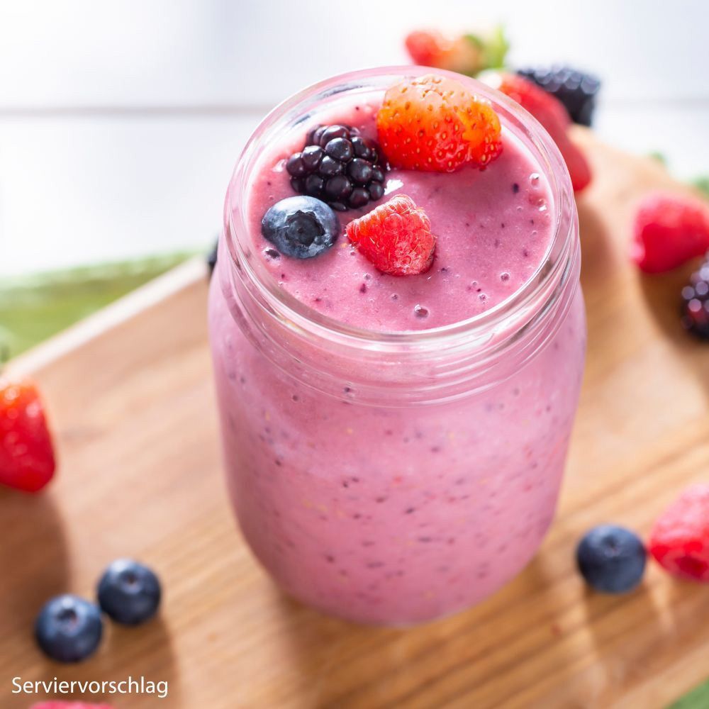 Ein Glas Beeren-Smoothie garniert mit frischen Beeren wie Erdbeeren, Blaubeeren und Brombeeren. Serviervorschlag.