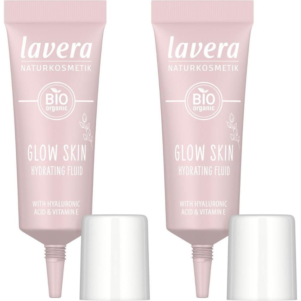 Zwei rosa Tuben Lavera Glow Skin Hydrating Fluid mit Hyaluronsäure und Vitamin E. Weiße Kappen liegen daneben.