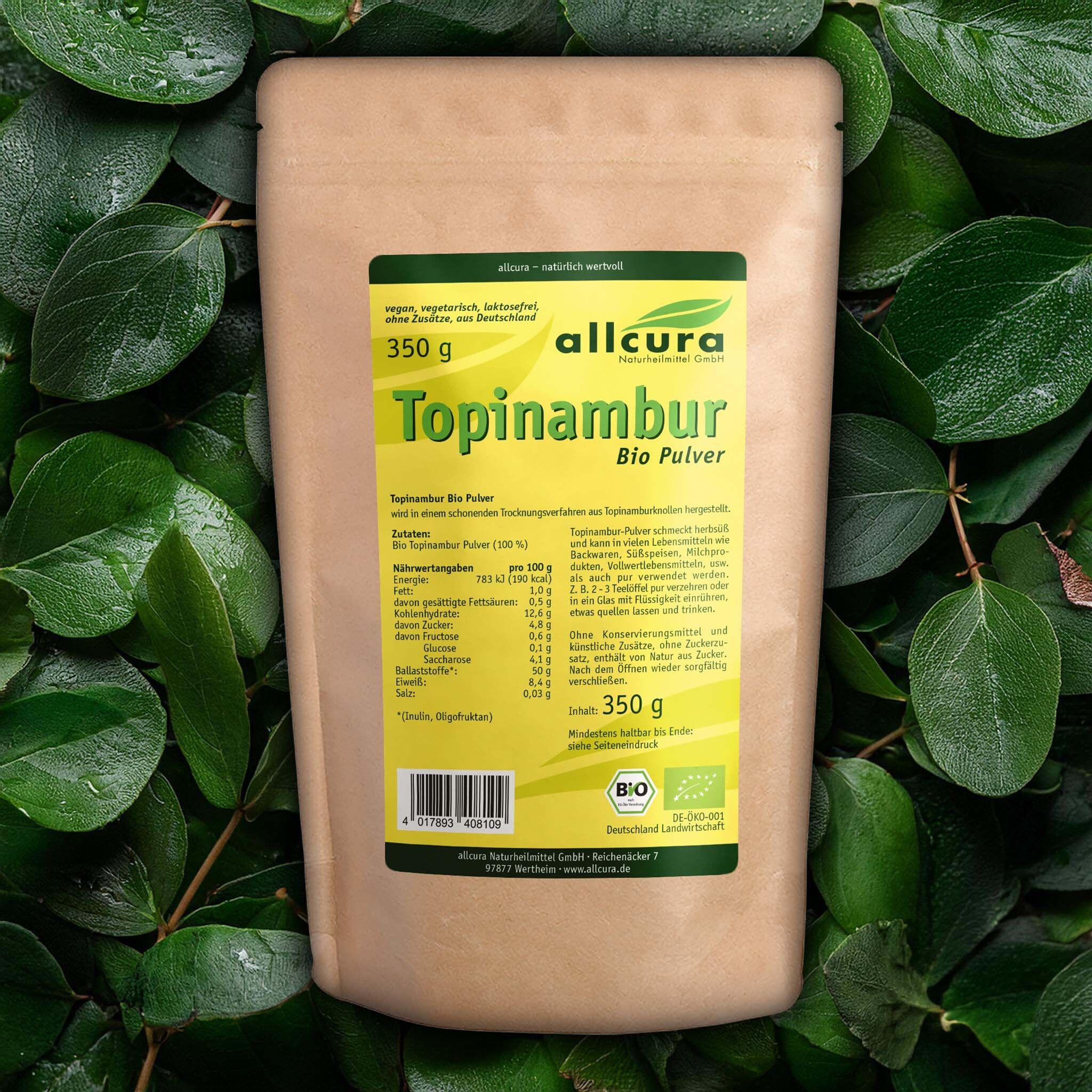 Brauner Beutel mit grünem Etikett. Aufschrift: allcura Topinambur Bio-Pulver, 350 g. Logo und Bio-Siegel. Text mit Nährwertangaben. Hintergrund: grüne Blätter.