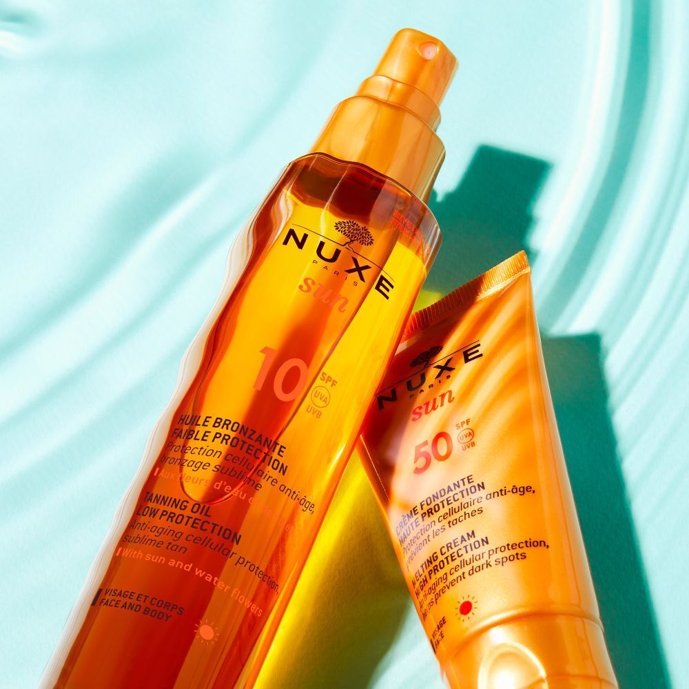 NUXE Sun Sonnenöl LSF 10 und Sonnencreme LSF 50. Text: Huile Bronzante, Crème Fondante. Auf blauem Hintergrund.