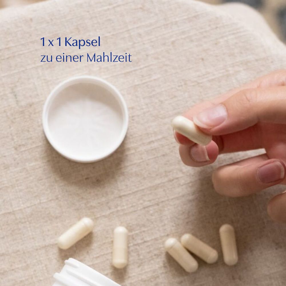 Offener Deckel mit Kapseln. Hand hält eine Kapsel. Kapseln sind hellbeige. Text: 1 x 1 Kapsel zu einer Mahlzeit.