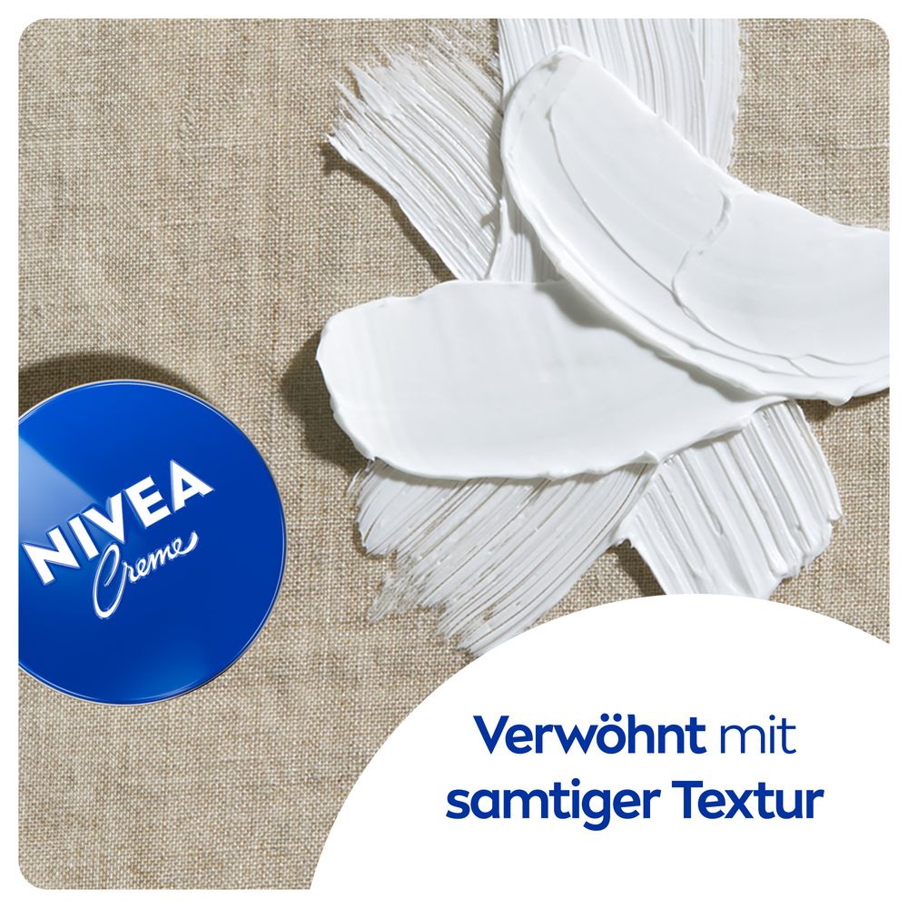 Weiße Creme-Spuren auf Leinenstoff neben NIVEA Creme Dose, Text "samtiger Textur".