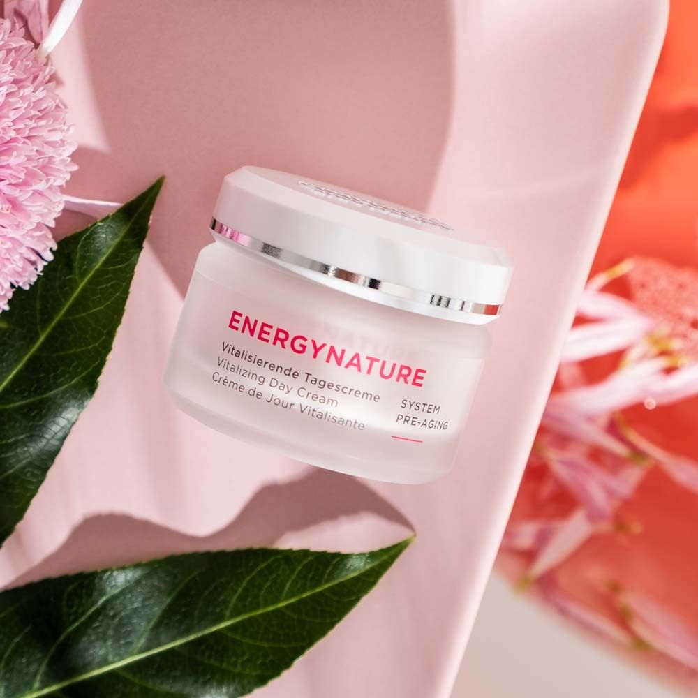 Creme-Tiegel mit Aufschrift ENERGYNATURE, Vitalisierende Tagescreme. Auf rosa Untergrund mit Blättern.