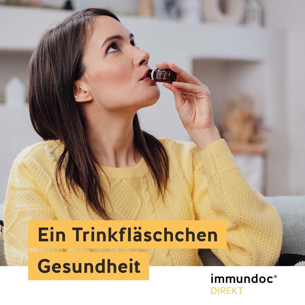 Frau trinkt aus einer Flasche immundoc® DIREKT. Gelber Pullover. Flasche mit brauner Flüssigkeit.