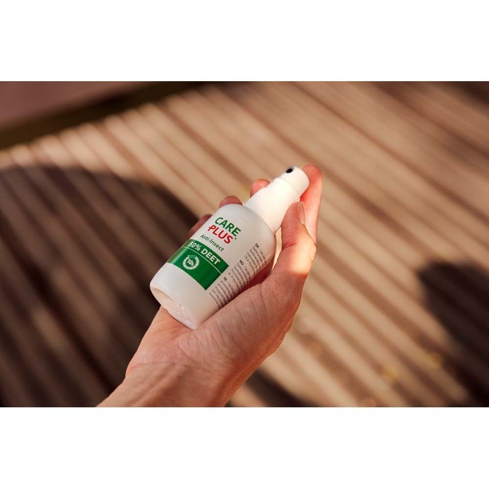 Weiße Care Plus Sprayflasche in einer Hand. Aufschrift: 50% DEET.