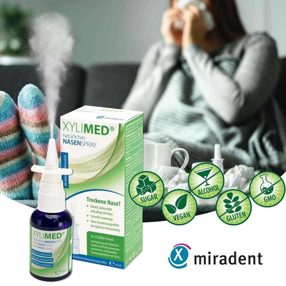 Person mit Nasenspray und Verpackung. XYLIMED® Nasenspray, grüne Verpackung, Logo, Zertifizierungen. Person mit Taschentüchern.