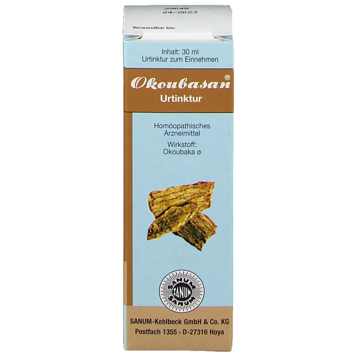 Produktverpackung. Beschriftung: OKOUBASAN® Urtinktur. Hersteller: SANUM-KEHLBECK GmbH & Co. KG. Abbildung von Holzstücken.