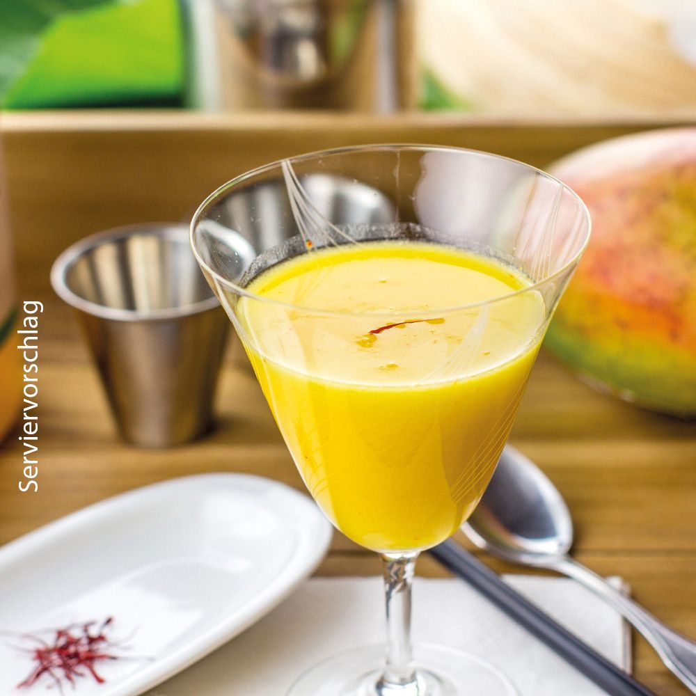Gelbes Getränk in einem Glas. Garniert mit Safran. Servierbeispiel.
