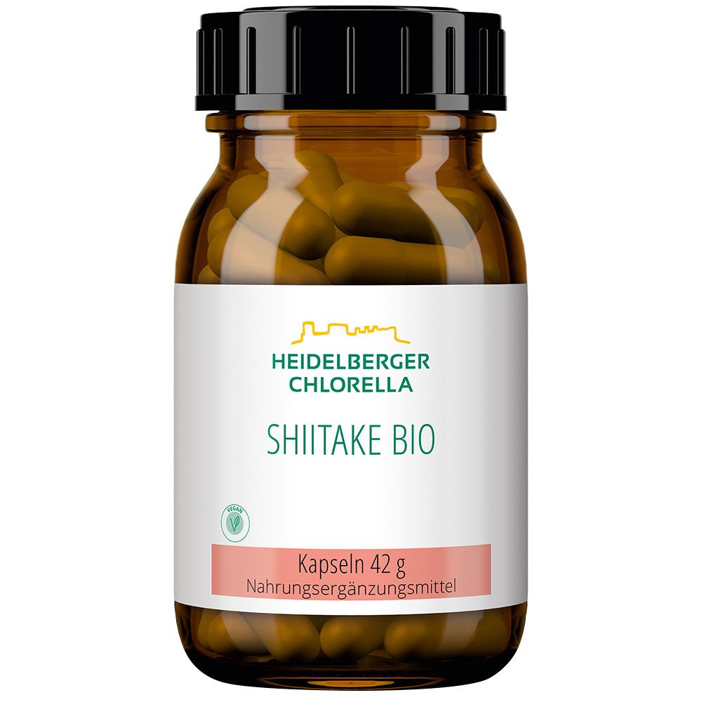 Braune Glasflasche mit schwarzen Deckel. Etikett mit "Heidelberger Chlorella Shiitake Bio". Kapseln sichtbar.