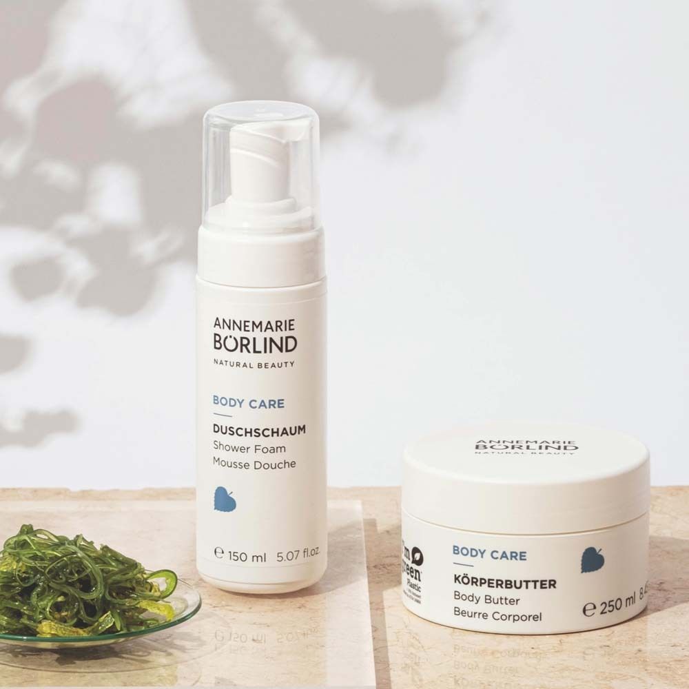 Weiße Flasche und Tiegel. Aufschrift: ANNEMARIE BÖRLIND, BODY CARE, DUSCHSCHAUM, 150 ml. Und Körperbutter.