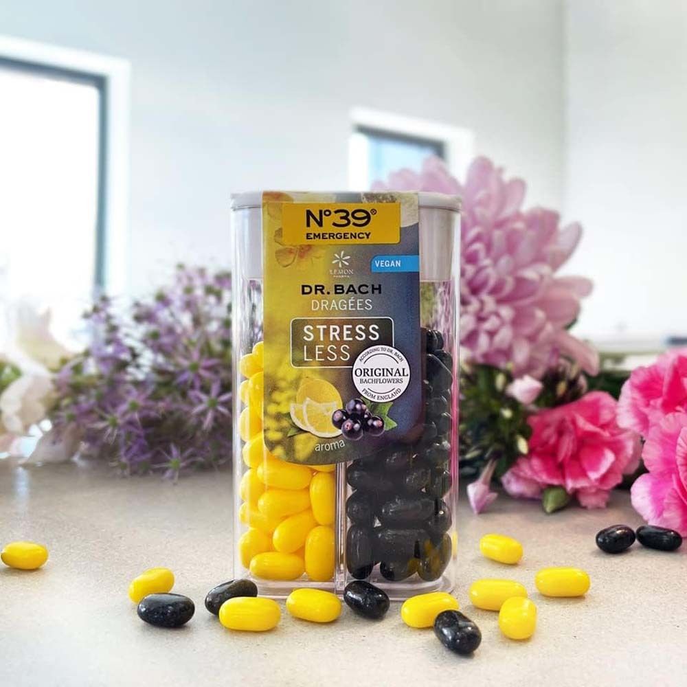 Zwei-Kammer-Behälter mit gelben und schwarzen Dragées auf einer Oberfläche. Aufschrift: N°39 Emergency, Dr. Bach Dragées, Stress Less.