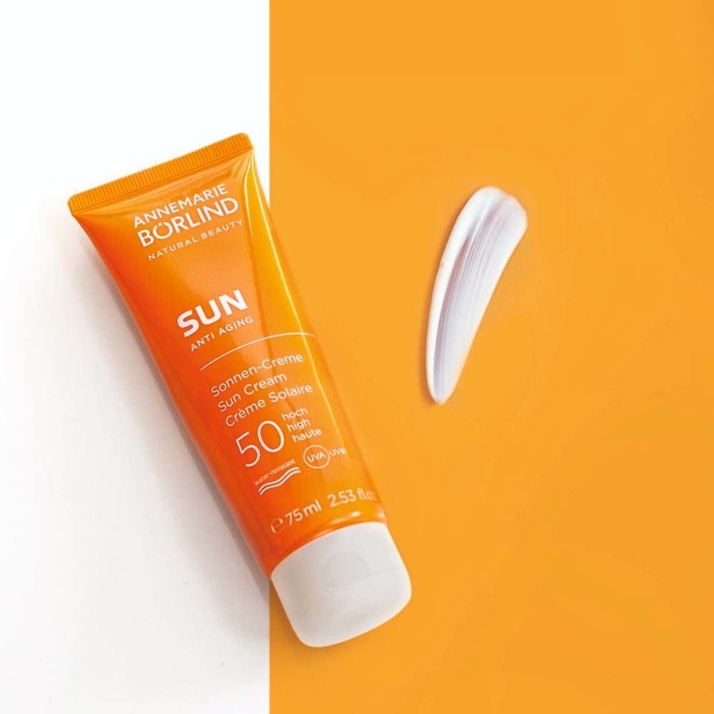 Orange Tube Sonnencreme und Klecks Creme. Text: ANNEMARIE BÖRLIND SUN Anti-Aging, LSF 50. 75 ml.