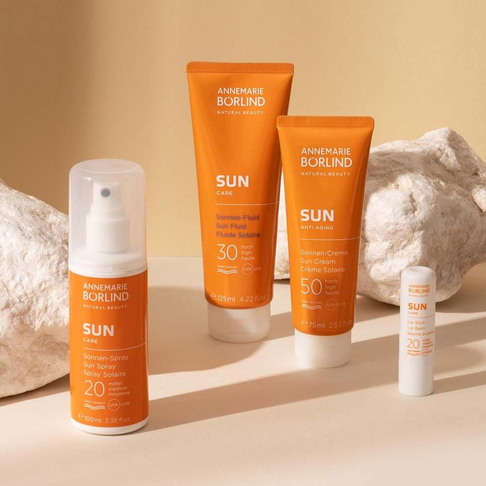 Verschiedene Sonnenpflegeprodukte. Sprays, Cremes, Lippenbalsam. Text: ANNEMARIE BÖRLIND SUN Care.
