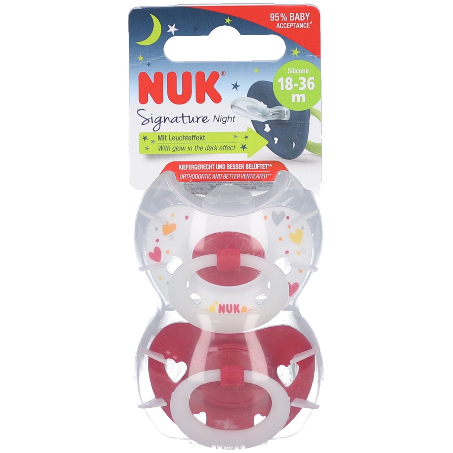 Zwei Schnuller in Verpackung. Rot-weiße Silikon-Sauger. Verpackung mit Produktnamen, Altersempfehlung und Leuchteffekt-Hinweis.