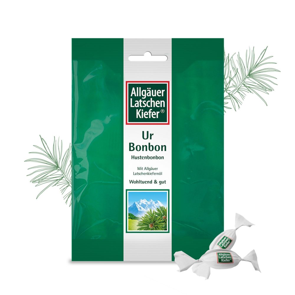Grüne Verpackung mit "Allgäuer Latschenkiefer Ur Bonbon". Einzelne Bonbons daneben. Zweige.