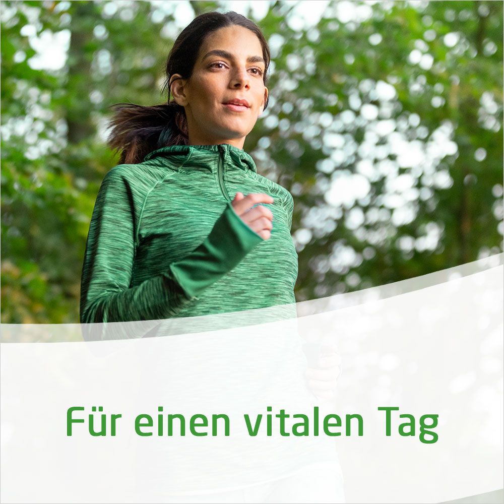 Eine Frau in grüner Sportkleidung joggt im Freien. Im Hintergrund Bäume.