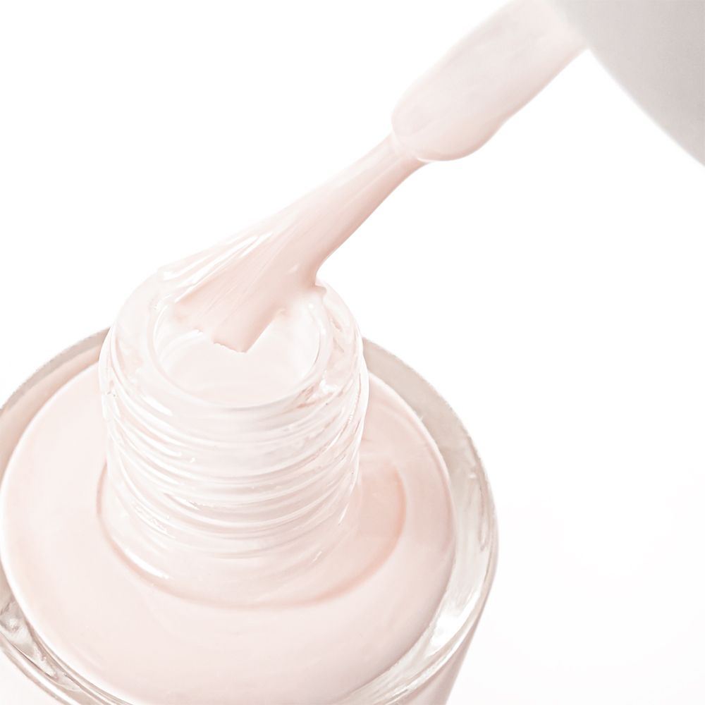 Nagellackbürste in einer Nagellackflasche. Rosa Nagellack. Weißer Deckel.