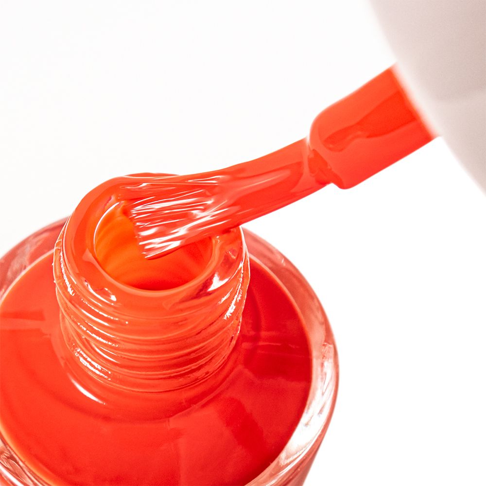 Nagellackbürste in Nagellackflasche. Roter Nagellack. Bürste mit Lack benetzt. Flasche mit rotem Lack gefüllt.