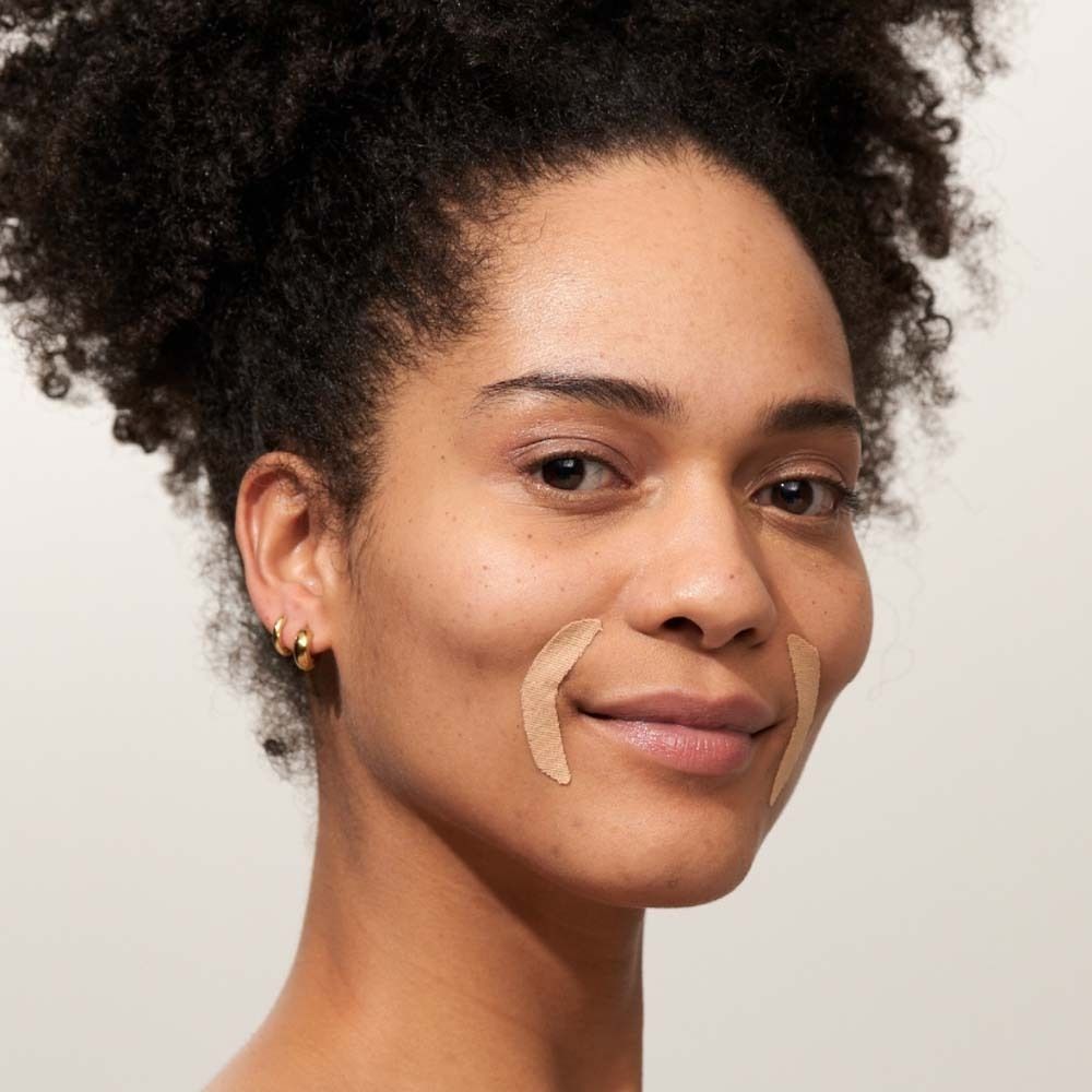 Frau mit Mund-Patches auf beiden Wangen. Beige Patches, V-förmig.