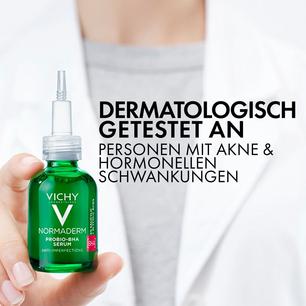 Serumflasche in Hand. Text: Dermatologisch getestet an Personen mit Akne & hormonellen Schwankungen.