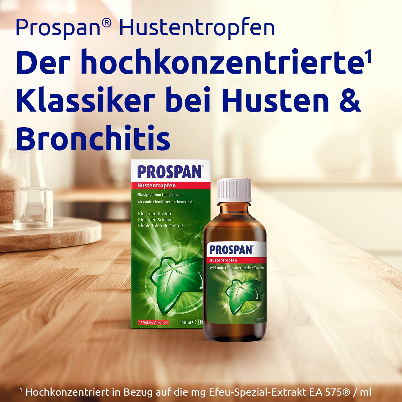 PROSPAN Hustentropfen, Flasche und Verpackung. Auf Holztisch. Braune Flasche, grüne Blattform. 100 ml.
