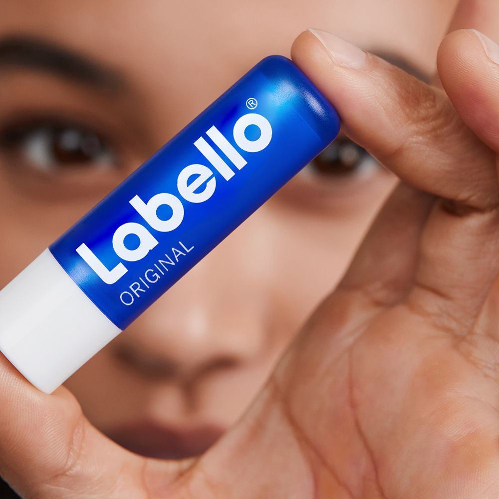 Nahaufnahme einer Hand, die einen Labello Original Lippenbalsam hält.